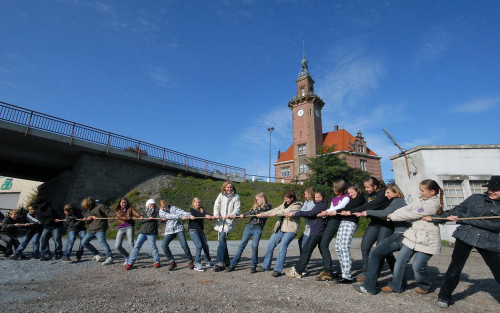 Vor dem alten Hafenamt in Dortmund spielt eine Gruppe Kinder Seilziehen.