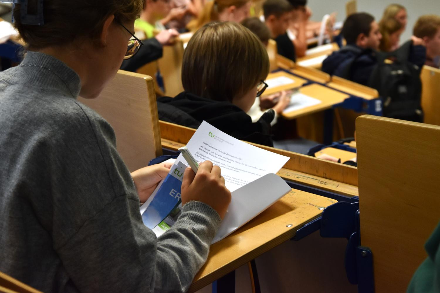 Kinder und Jugendliche in einem Hörsaal.
